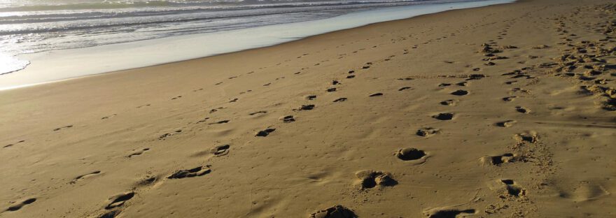 Strand in Mimizan Plage in Frankreich. Man sieht Fußspuren im Sand und den Atlantischen Ozean